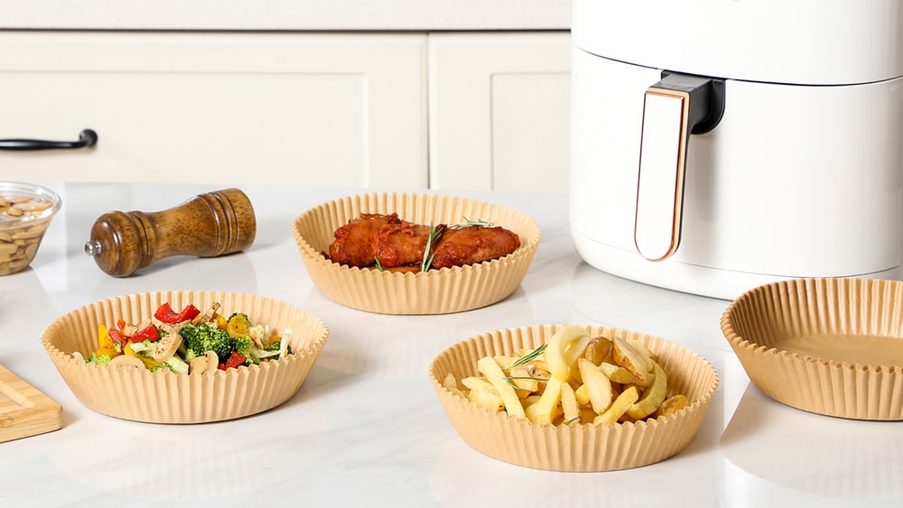 An open air fryer basket with a pleated paper liner inside