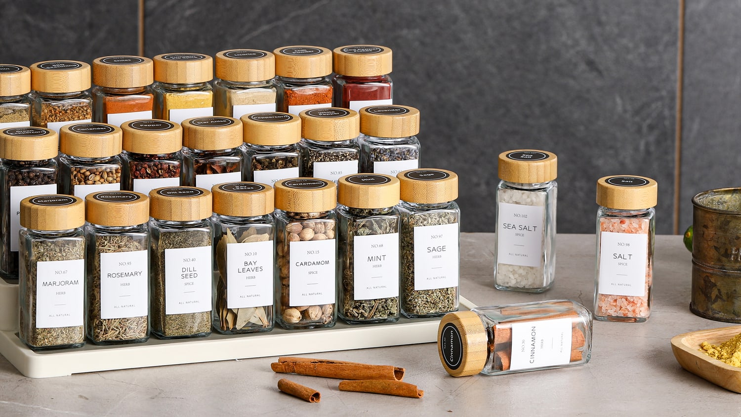 A kitchen rack of small glass spice jars with bamboo lids