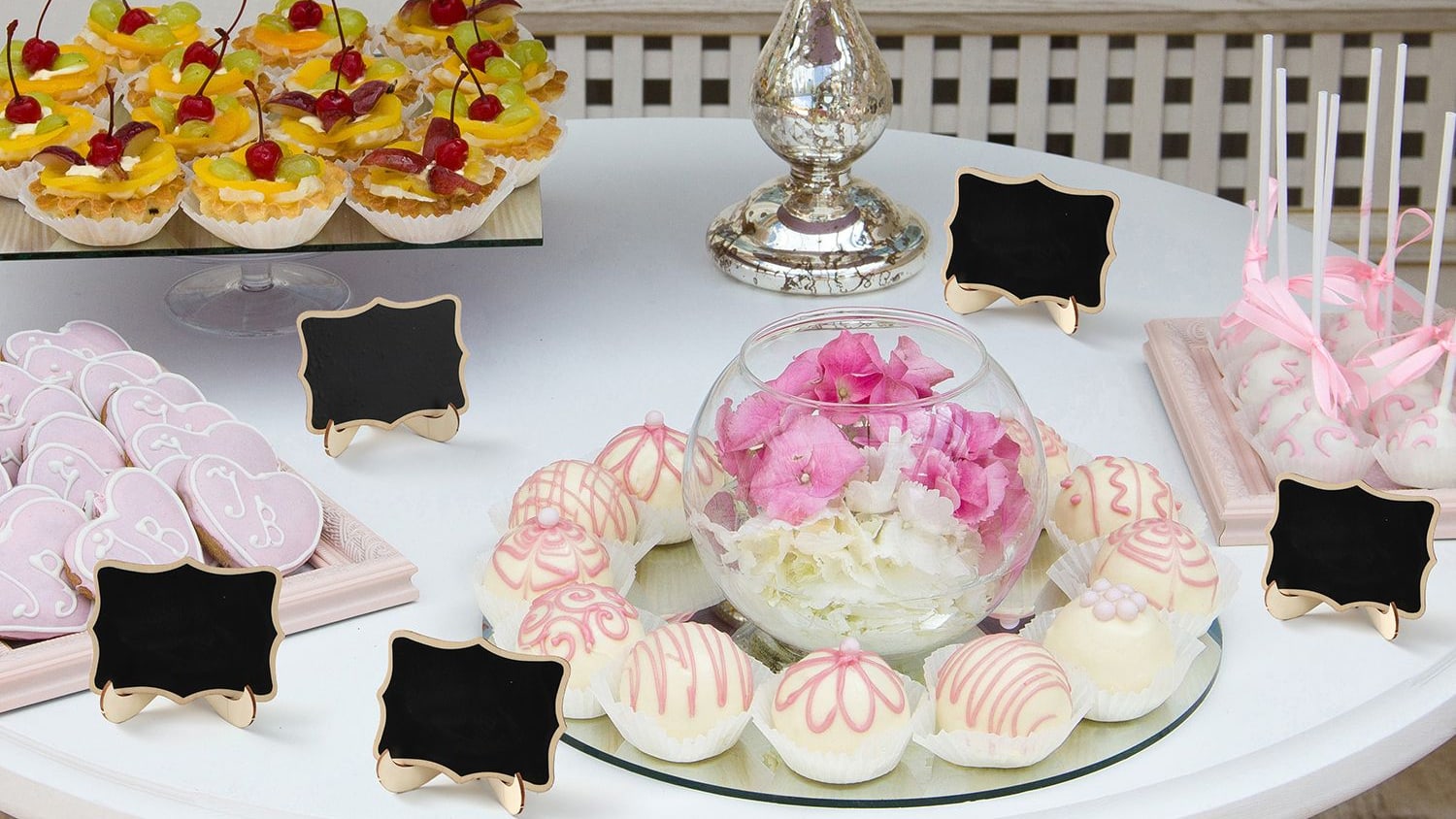 A dessert table set with small jars and miniature chalkboard signs